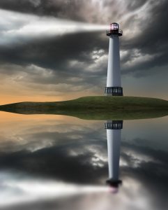 Lighthouse beaming light ray over stormy clouds.